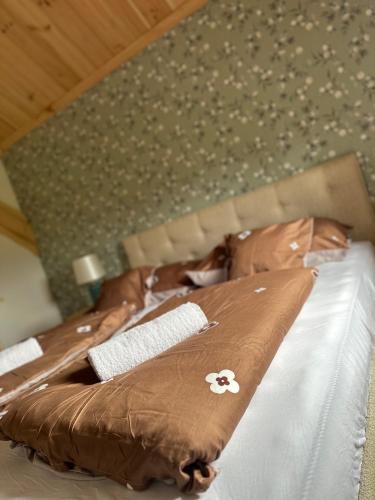 two beds with brown and white comforters on them at Edenski vrt in Ivančna Gorica