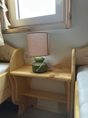 a lamp on a wooden table in a bedroom at Edenski vrt in Ivančna Gorica