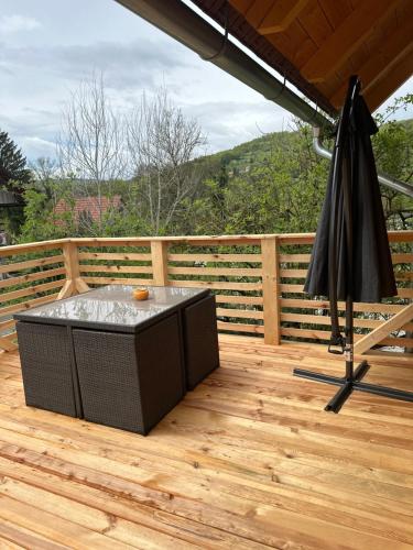 an umbrella sitting on a deck with a table at Edenski vrt in Ivančna Gorica
