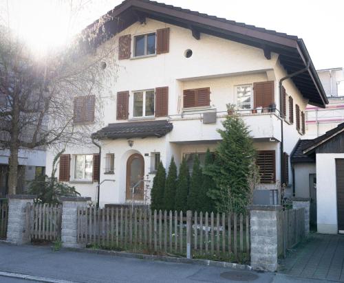 a white house with a wooden fence at Gartenoase by Greatlifestay in Ennetbürgen
