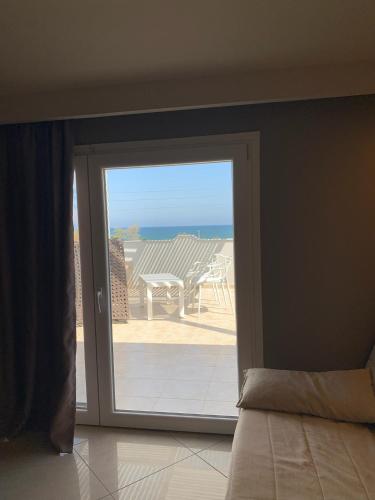 a door to a patio with a view of the ocean at Rodolithos Beach in Stavros