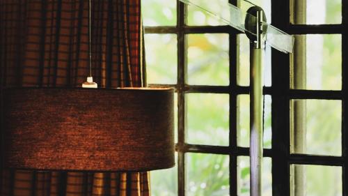 a lamp in a room with a window at CASA ACAYU in São Miguel dos Milagres