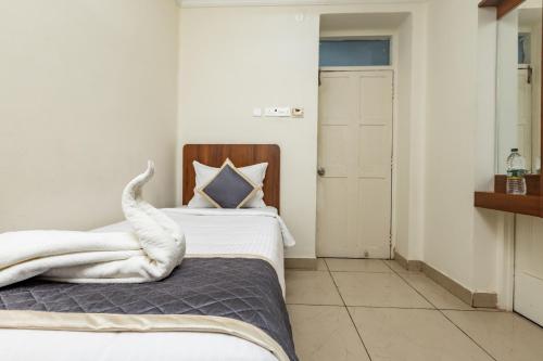 a bedroom with a bed with a towel on it at Hotel Lakshmi Grand in Chennai