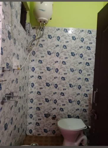 a bathroom with a toilet and a shower curtain at Kartikey homestay and restaurant in Gopeshwar