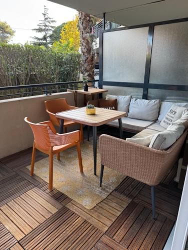un patio avec un canapé, une table et des chaises dans l'établissement L'appart idéal famille, terrasse, piscine, plage, à Villeneuve-Loubet
