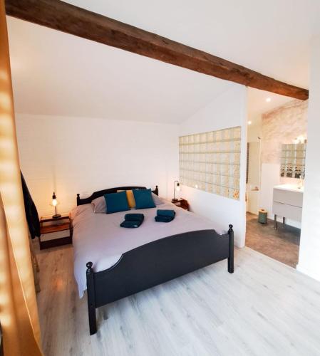 une chambre avec un grand lit dans une pièce dans l'établissement Les Orangers - LOGEMENT INDÉPENDANT - 2 personnes - Patio - PROCHE DES THERMES DE SAUJON, DU GOLF ET DU CENTRE DE ROYAN, à Royan