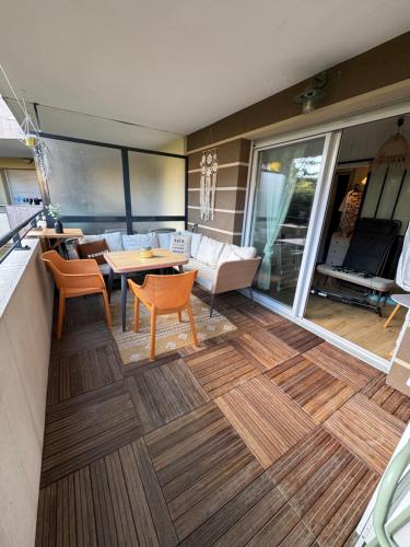 - un salon avec une table et des chaises sur une terrasse dans l'établissement L'appart idéal famille, terrasse, piscine, plage, à Villeneuve-Loubet