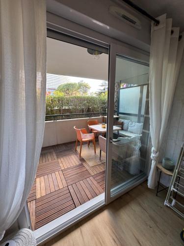 d'un balcon avec une porte coulissante en verre et une table. dans l'établissement L'appart idéal famille, terrasse, piscine, plage, à Villeneuve-Loubet