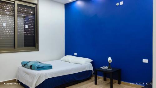 a blue room with a bed and a side table at Country House in Wadi Musa