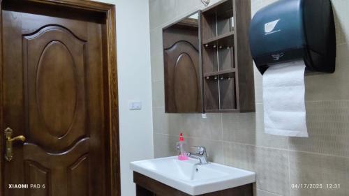 a bathroom with a sink and a paper towel dispenser at Country House in Wadi Musa