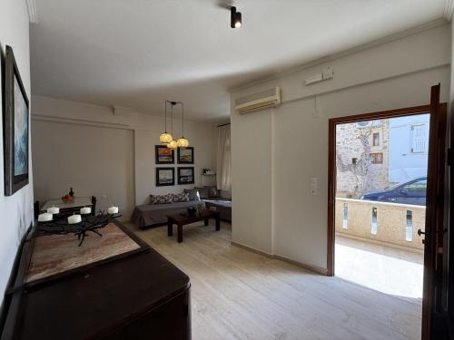 a living room with a large window and a couch at Mariliana Apartments Just 15 Steps from the Libyan Sea in Myrtos