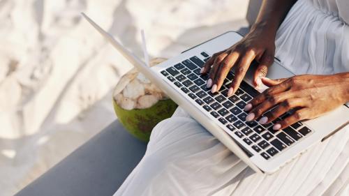 a woman typing on a laptop computer on her lap at CASA ACAYU in São Miguel dos Milagres