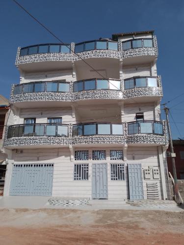 a tall white building with doors and windows at Deluxe in Ziguinchor