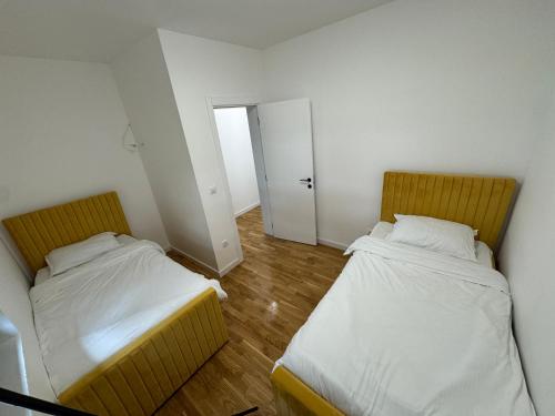 two beds in a small room with a hallway at The Crown Pool Villa in Belgrade
