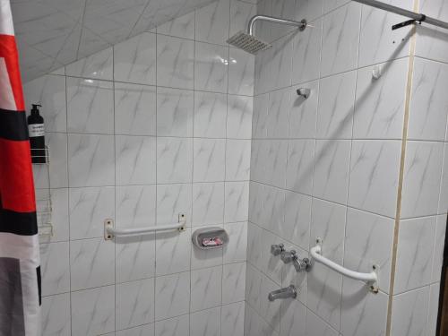 Un baño con ducha con azulejos blancos. en La casa de Chiqui, en Mendoza