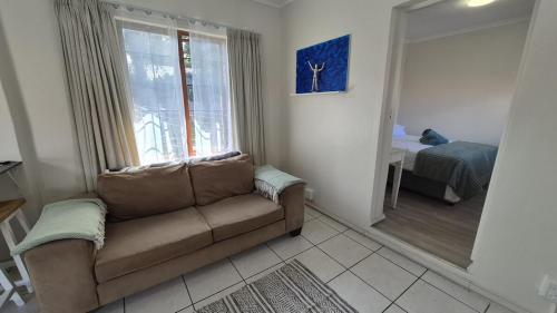 a living room with a couch and a bedroom at Chase Valley Hideaway in Pietermaritzburg