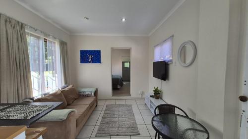 a living room with a couch and a table at Chase Valley Hideaway in Pietermaritzburg