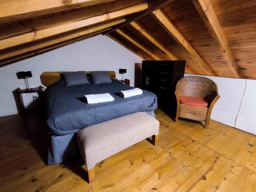 a bedroom with a bed and a chair in a attic at Villa La Angostura in Villa La Angostura