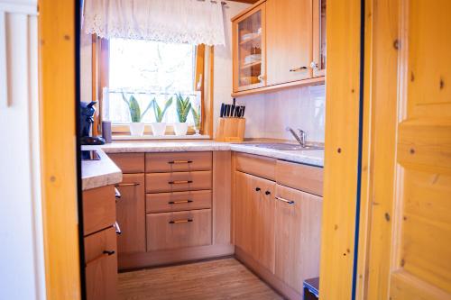 a kitchen with wooden cabinets and a window at WaldSeeLiebe in Pinnow