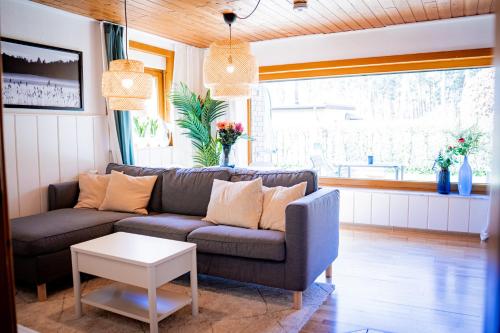 a living room with a couch and a table at WaldSeeLiebe in Pinnow