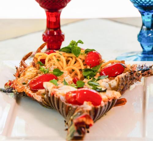 a slice of pizza with spaghetti and tomatoes on a table at CASA ACAYU in São Miguel dos Milagres