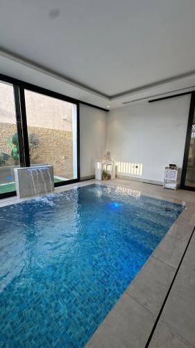 a large swimming pool with blue water in a room at Villa 22 in Ajman 