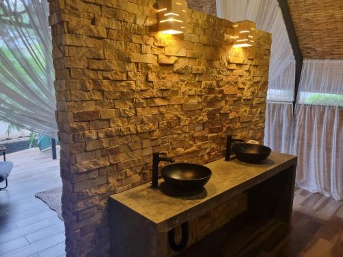 a bathroom with two bowls on a brick wall at Beach Front Condo for 10 people in Tamarindo