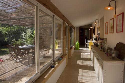 un couloir avec des portes coulissantes en verre et une terrasse dans l'établissement Maison à la campagne avec piscine privée, à Marsalès