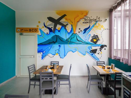 a dining room with tables and a mural on the wall at Terminal 1 Guest House in Naples