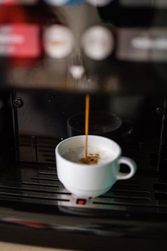 a cup of coffee with a spoon in a microwave at Terminal 1 Guest House in Naples