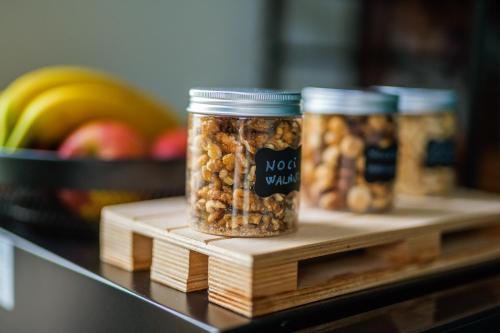 three jars of nuts on a wooden shelf with fruit at Terminal 1 Guest House in Naples