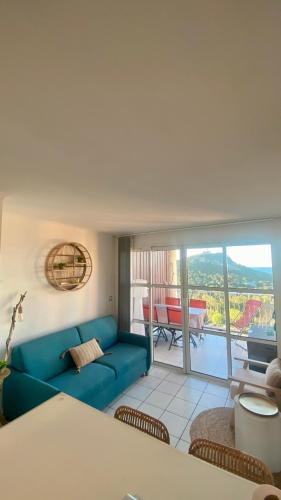 un salon avec un canapé bleu et un balcon dans l'établissement Le rêve d'azur, à Saint-Raphaël