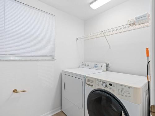 a laundry room with a white washer and dryer at SUPER BOHO- At LAKE TOHO's WATER SLEEPs 6 in Kissimmee