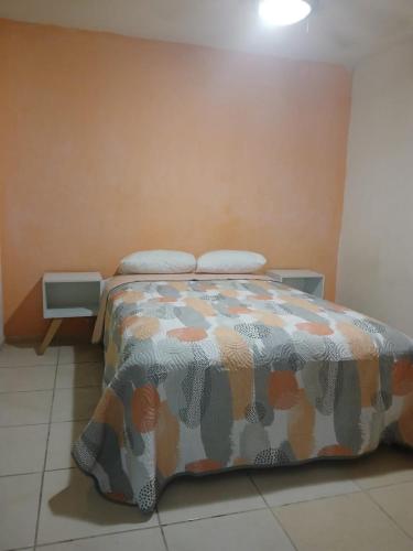 a bed in a room with two pillows on it at Departamento cerca de la playa in Puerto Vallarta