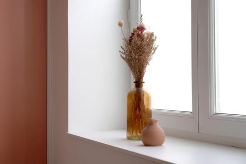 a vase sitting on a window sill with a flower at Charmant appartement Lille Centre St Michel in Lille