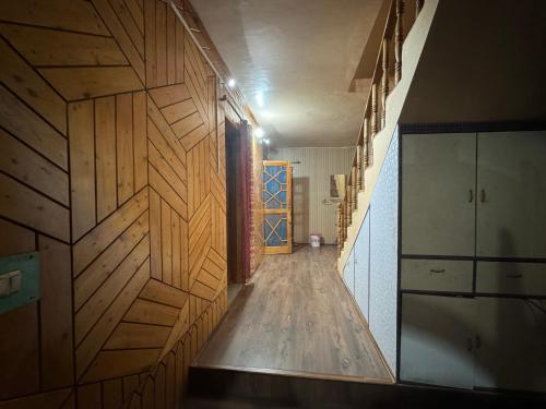 a hallway with wooden walls and a wooden floor and a door at Peak View Guest House Gurez in Wāmpor
