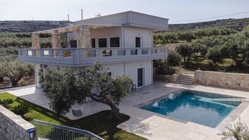 a house with a swimming pool in front of it at Villa Avelios in Karefilianá