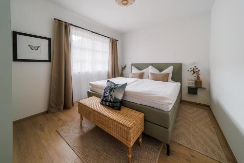 a bedroom with a large bed and a wicker stool at Göllitzhof Appartements in Heinreichs bei Weitra