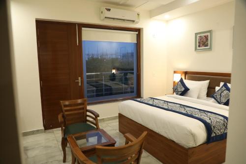 a hotel room with a bed and a window at Hotel Sandal tree express in Noida