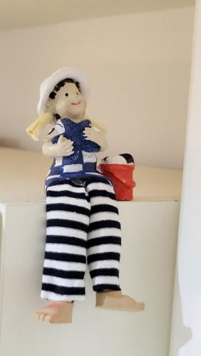 a doll is sitting on top of a shelf at "Sunny" in Burgtiefe auf Fehmarn 