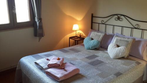 a bedroom with a bed with two stuffed animals on it at La Trucha del Arco Iris in El Acebo de San Miguel