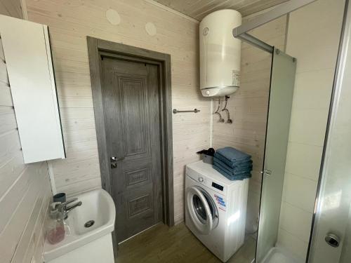 a small bathroom with a washing machine and a washer at Jaunas Ilgas in Medumi