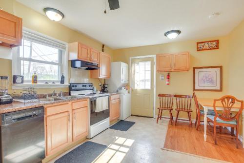 a kitchen with wooden cabinets and a table with chairs at 7 Mi to Dtwn Dayton Home in Kettering with Yard in Dayton