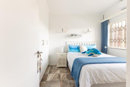 a bedroom with a bed with a blue stuffed animal on it at Ocean View Escape with Private Rooftop -Sancta Maria in Kingsburgh