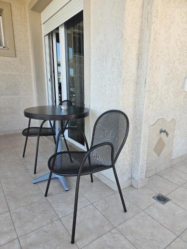 a black table and chairs sitting next to a window at Rodolithos Beach in Stavros