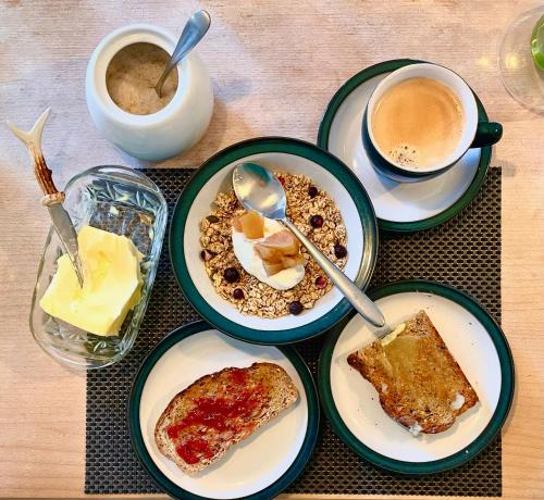 a table with plates of breakfast food and a cup of coffee at Cottage Guest House Nr Cheltenham on Cotswold Edge in Churchdown