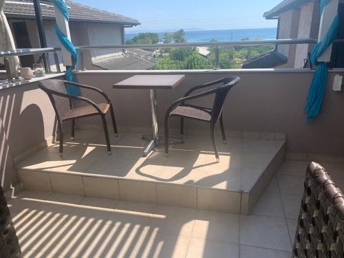 a patio with two chairs and a table on a balcony at Rodolithos Beach in Stavros