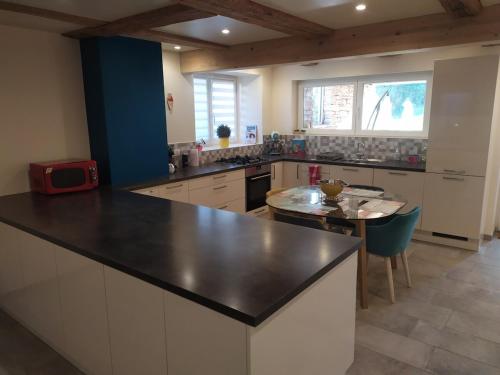 une cuisine avec un comptoir noir et une table dans l'établissement La maison des trois frontières, à Wolschwiller