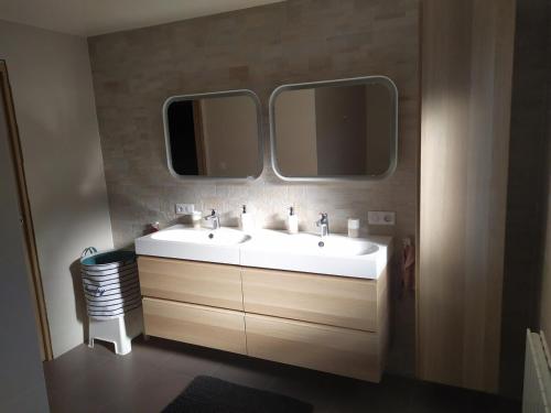 une salle de bain avec deux lavabos et deux miroirs dans l'établissement La maison des trois frontières, à Wolschwiller