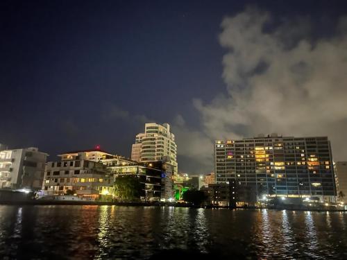 圣胡安Walking beach distance studio in Miramar San Juan的一座城市,晚上有建筑和水